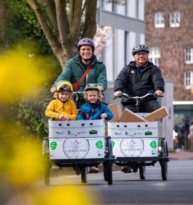 Personen fahren mit einem Lastenfahrrad Lastenräder