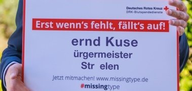 Bernd Kuse mit dem Plakat auf dem die Buchstaben fehlen