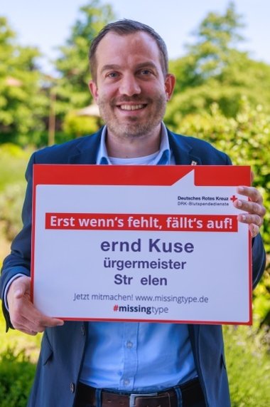 Bernd Kuse mit dem Plakat auf dem die Buchstaben fehlen