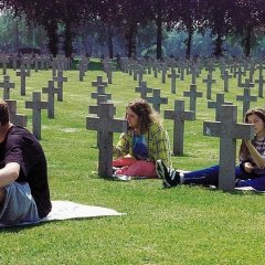 3 Jugendliche beschriften Grabsteine auf einem Friedhof